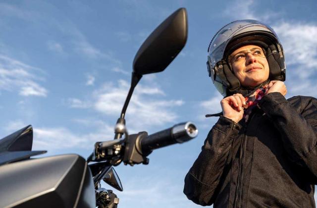 Frau zieht Motorradhelm an